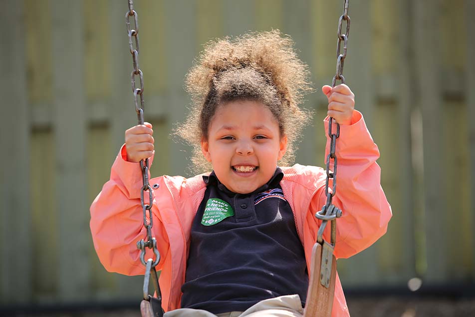 student in classroom smiling at camera