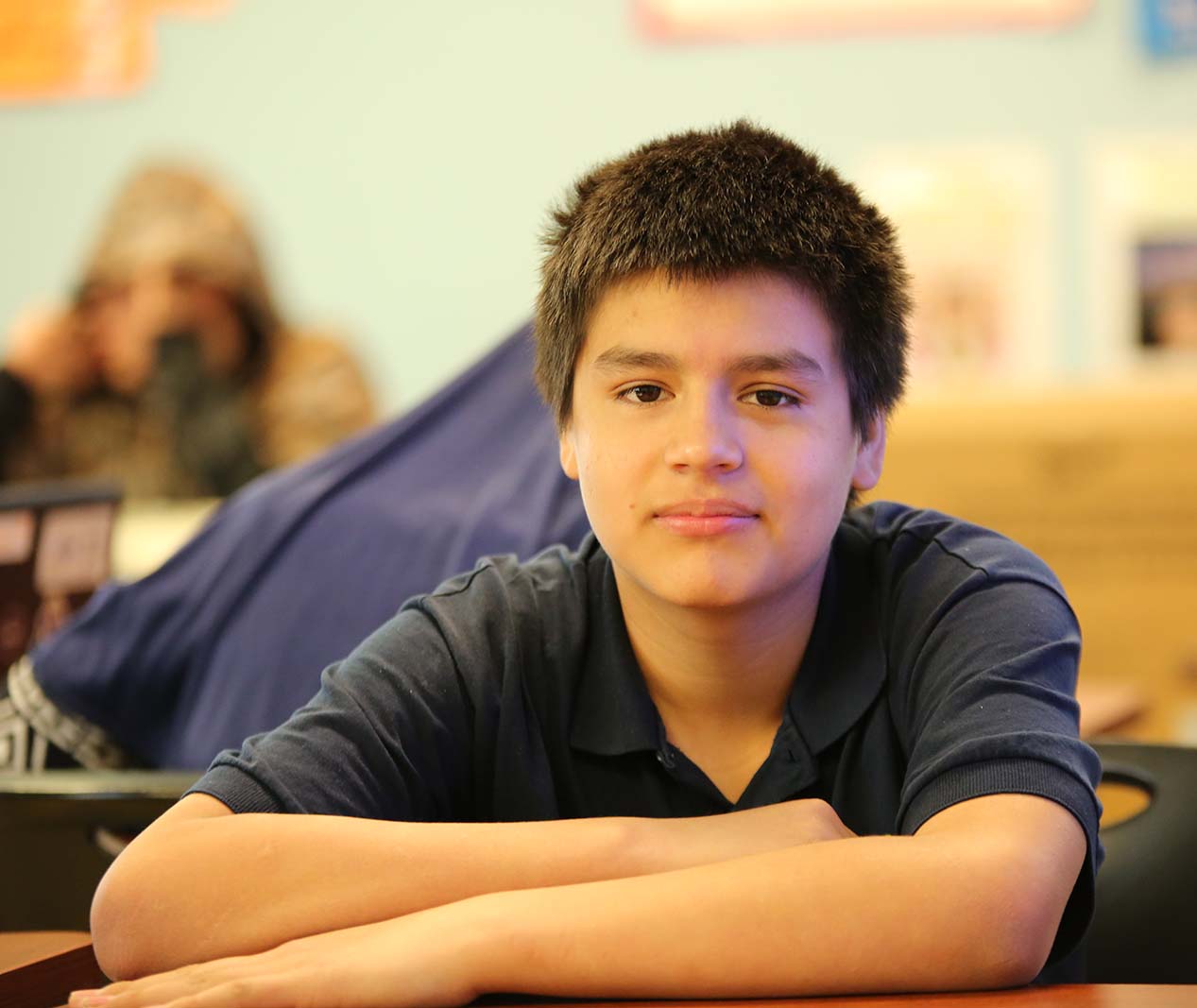Student working on a notebook in a classroom.